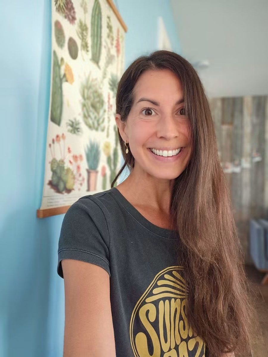Émilie souriante devant une affiche de cactus